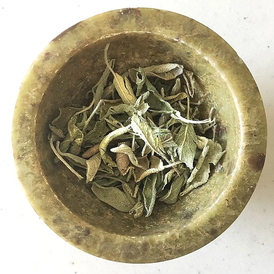 Dried sage leaves in a stone mortar
